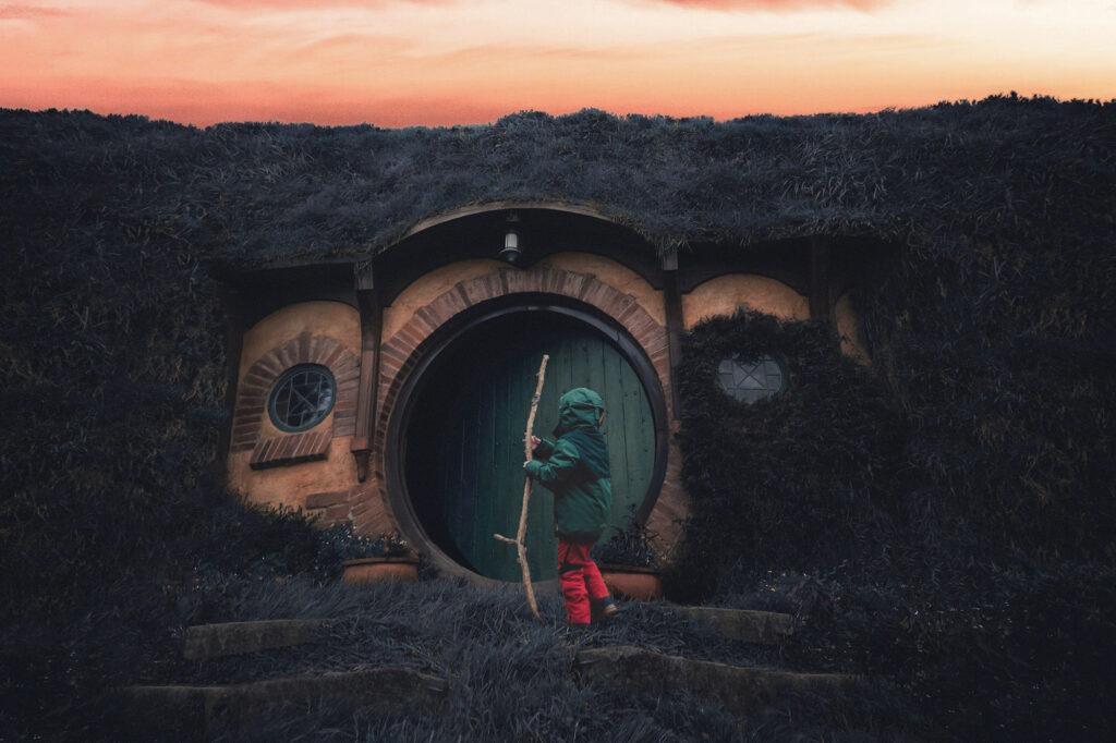 Illustration of a child standing at the door of small hut during